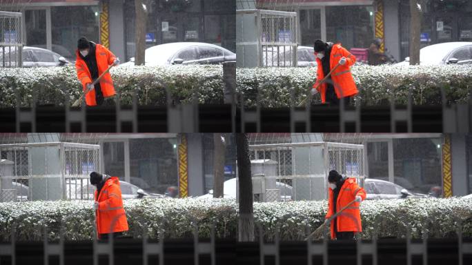 下雪天环卫工人挥动着扫帚扫除积雪