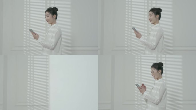 成熟气质职业装女白领走廊玩手机看手机消息