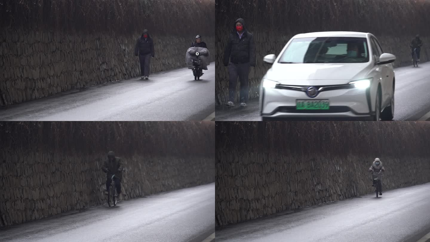 下雪天车辆驶过行人骑车人艰难的蹬着自行车