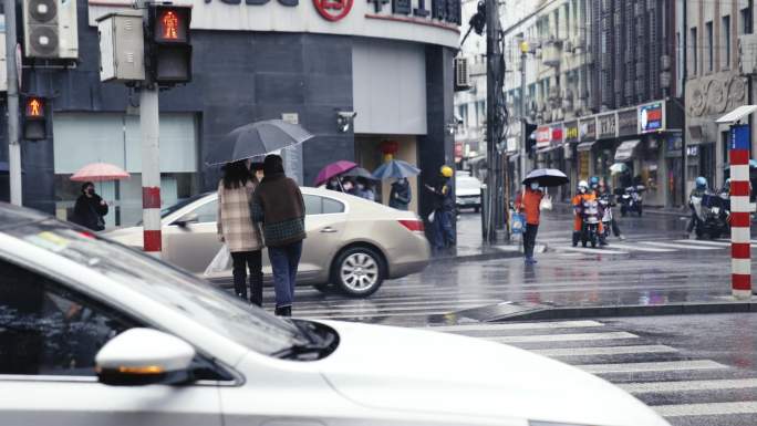 上海南京路下雨行人撑伞过马路斑马线车流