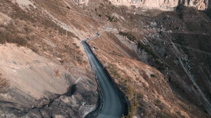 西南陡峭山崖公路行驶汽车