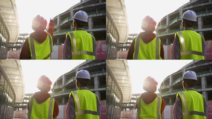 领导视察建筑工地团队逆光背影戴着安全帽