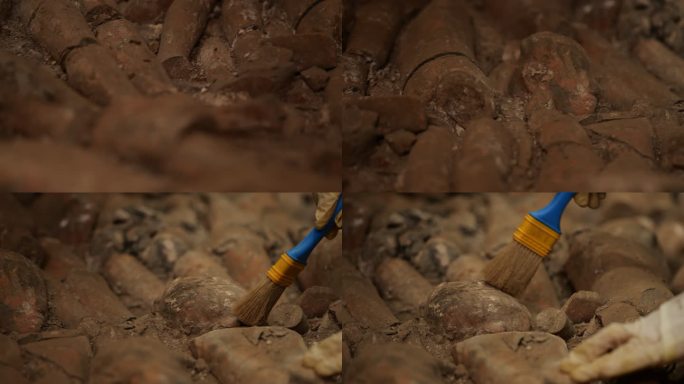 考古学家用刷子清理石像的沙子灰尘