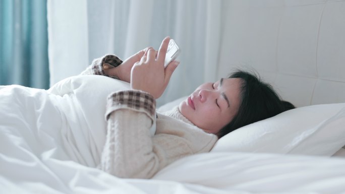 4K年轻女性躺在床上玩手机合集