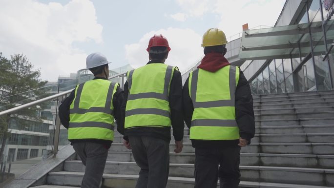 领导视察工地建筑工人上楼梯背影安全宣传