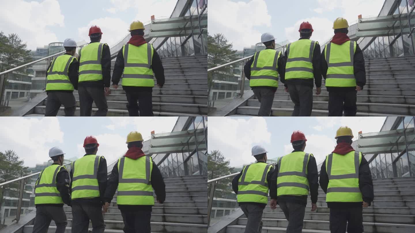 领导视察工地建筑工人上楼梯背影安全宣传