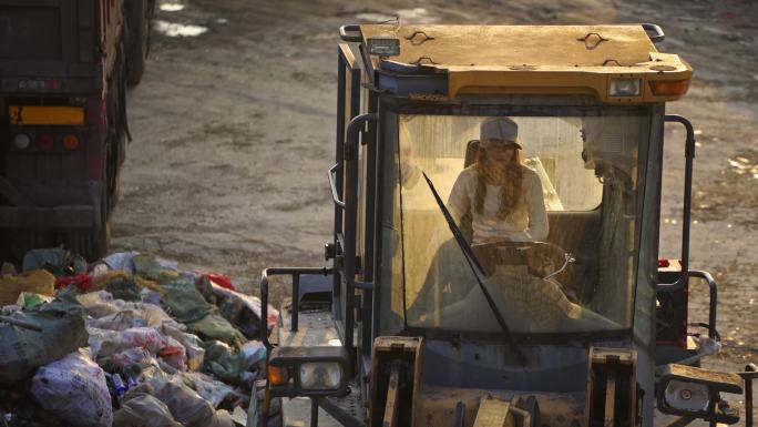 女人驾驶推土机清运废品垃圾
