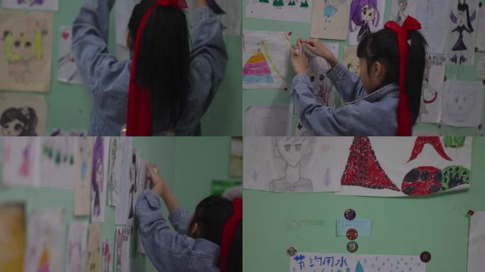 小女孩贴自己画上墙