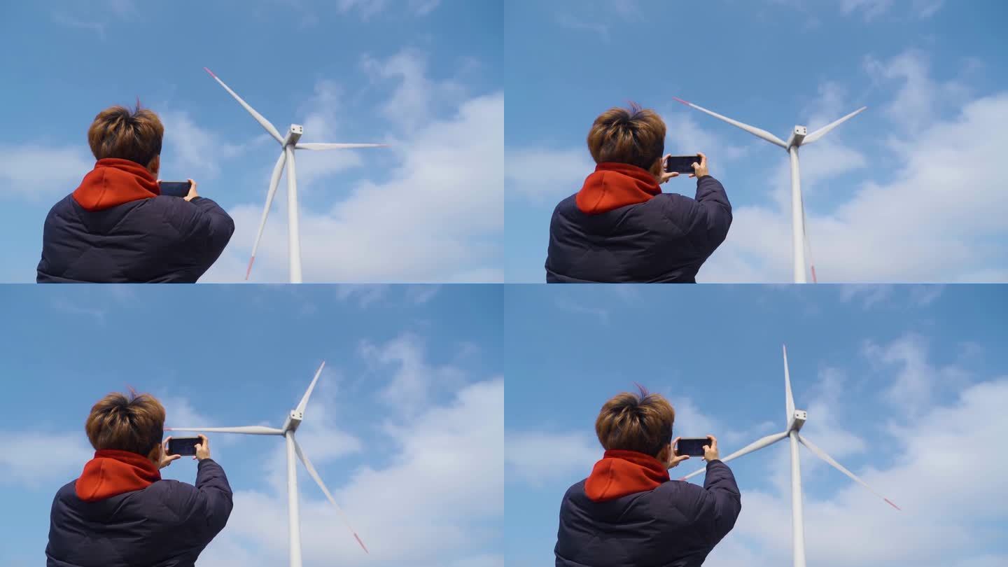 旅行者抬头仰望风力发电风车拍照阳光少年