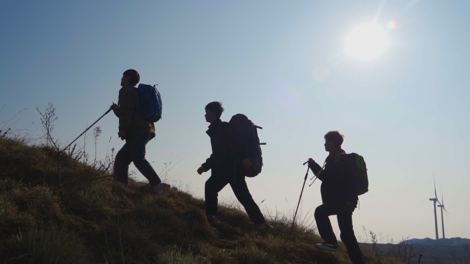 团队爬山剪影逆光登山脚步团队协作攀登顶峰