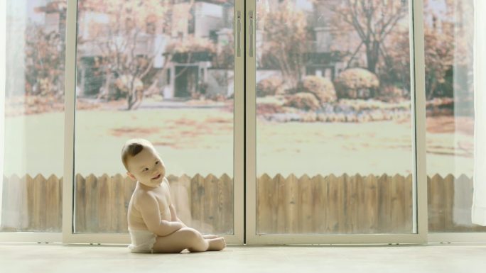 可爱的宝宝坐在客厅窗前欢笑特写