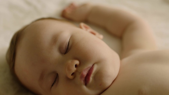 宝宝躺在婴儿床上舒服地睡午觉特写
