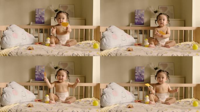 可爱的宝宝坐在婴儿床上玩玩具高帧素材