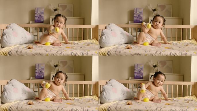可爱的宝宝坐在婴儿床上玩玩具 高帧素材