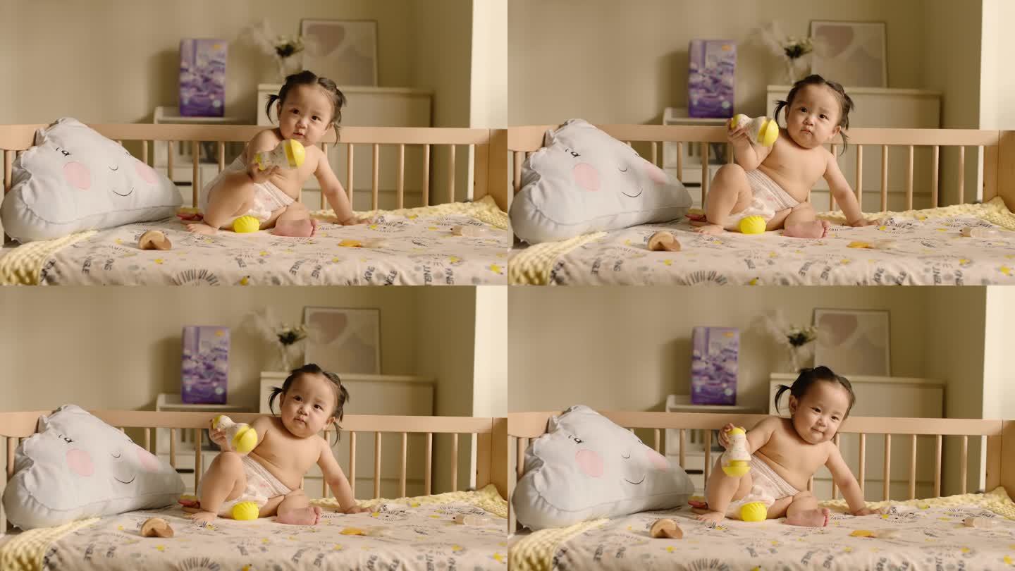 可爱的宝宝坐在婴儿床上玩玩具 高帧素材