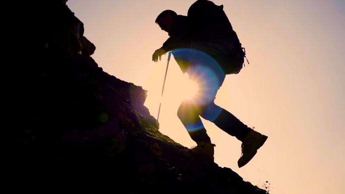 爬山逆光 登山 团队协作手拉手协助登山包