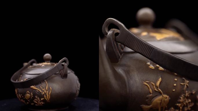 茶壶金色雕刻工艺品喝茶黑色背景特写鱼雕刻