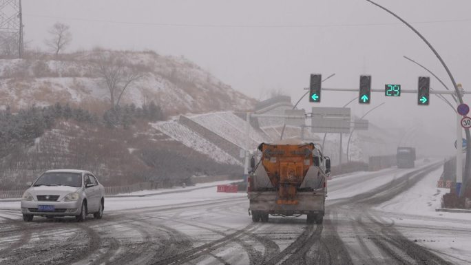 下雪天环卫车在道路上撒盐融化积雪