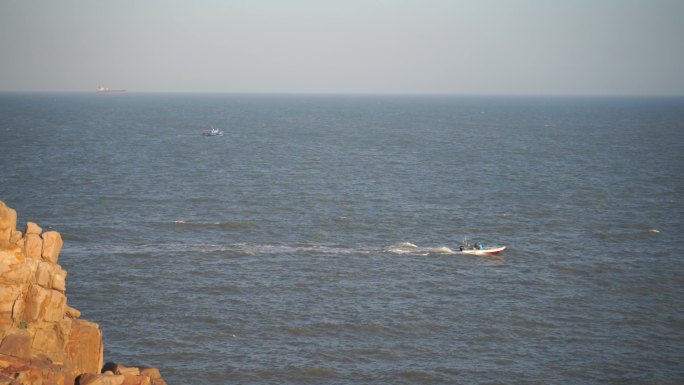 海平面上一只渔船驶过