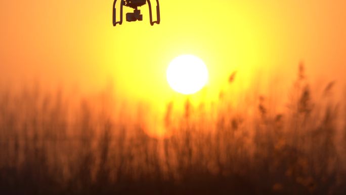 夕阳下的无人机由虚到实上升和下降画面拍摄