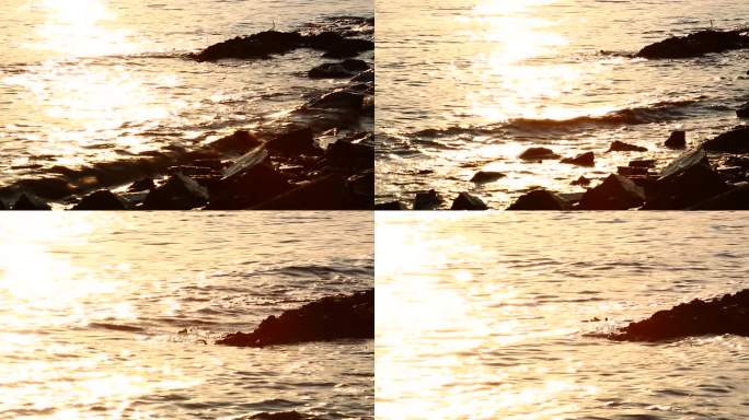 夕阳下海浪拍打礁石