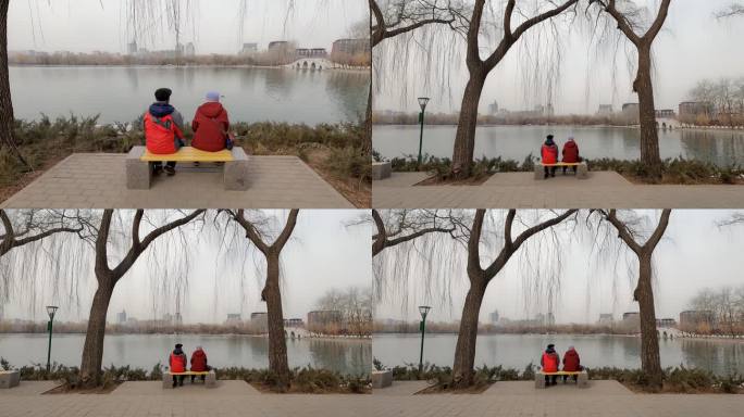 两位耄耋老人坐在冬天公园的座椅上