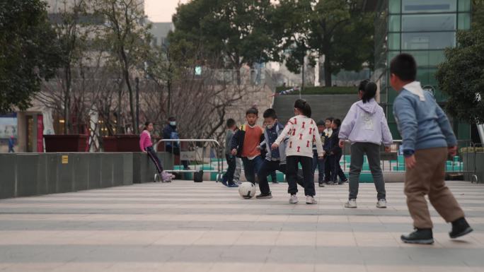 一群小孩子在广场上踢球
