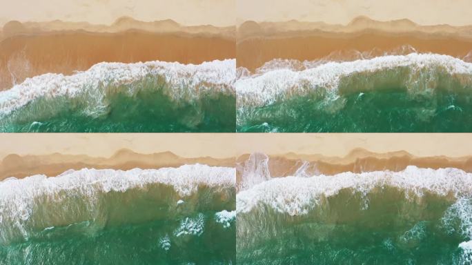 4k鸟瞰海浪沿着海岸拍成泡沫