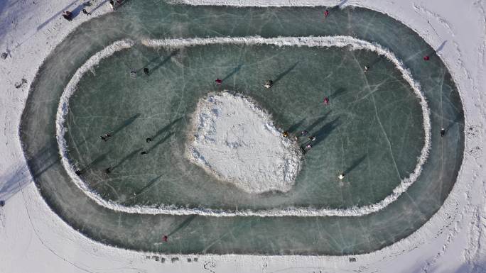 俯拍雪后冰湖滑冰人群