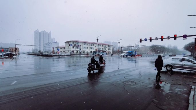 冬天下雪湿滑的路面十字路口红绿灯
