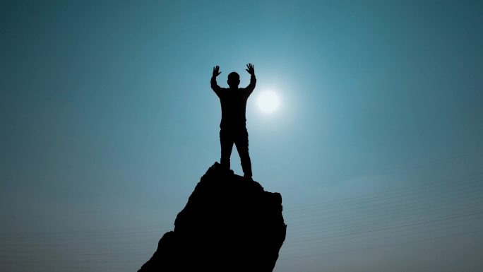男人山顶挥手庆祝成功登顶登山剪影勇攀高峰