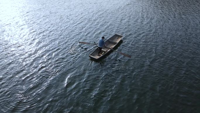 一叶孤舟湖面划船积极前进孤独身影意境概念