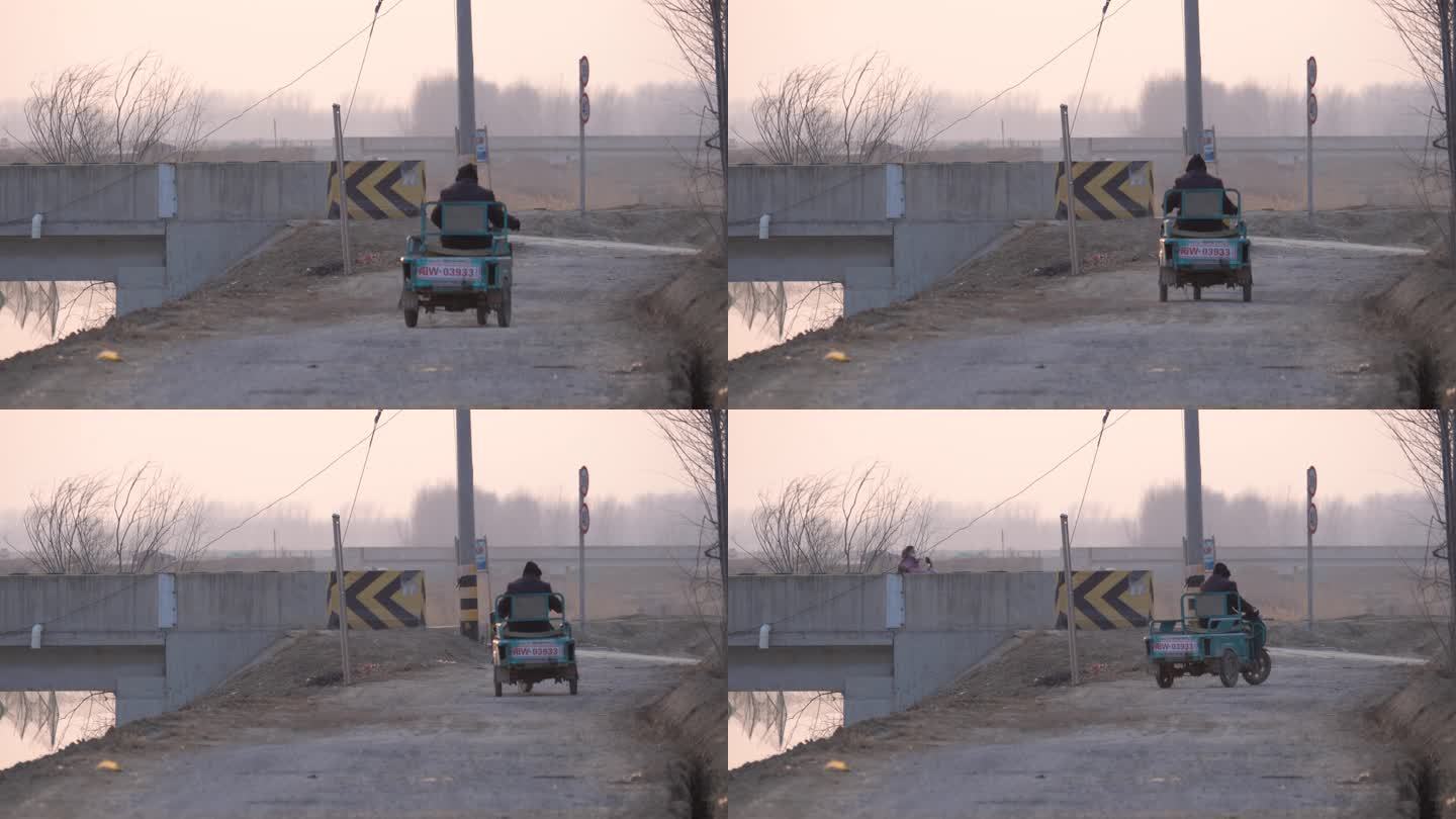 乡村傍晚一位老人骑着电动三轮车远去背影