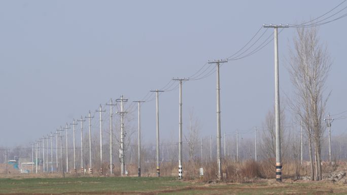 乡村农村田地里经过的电线杆一排电线杆