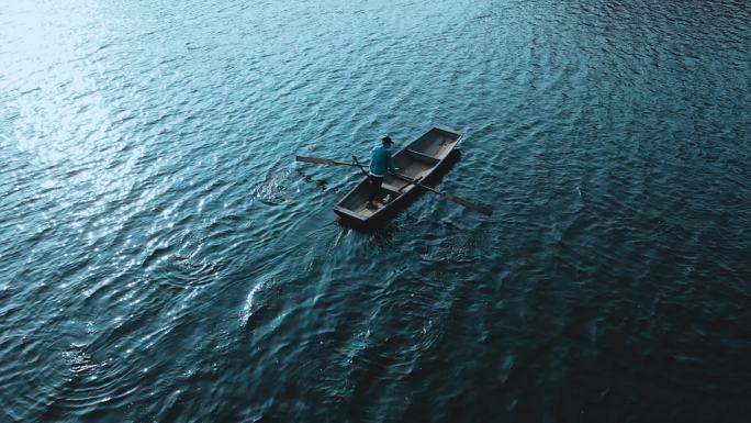 湖面划船一叶孤舟积极前进孤独身影意境概念