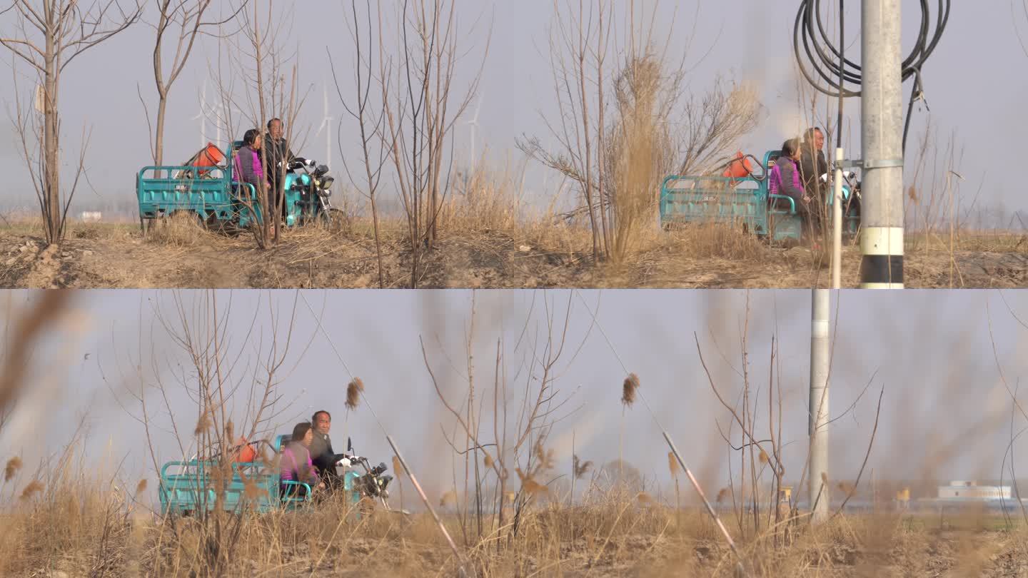 乡村一对夫妇骑着三轮车在路上经过