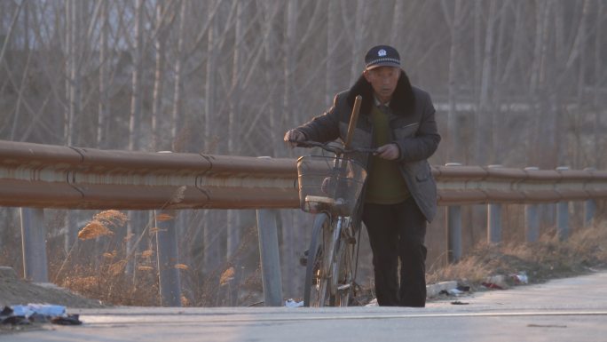 乡村人文一位老人吃力地推着自行车上坡