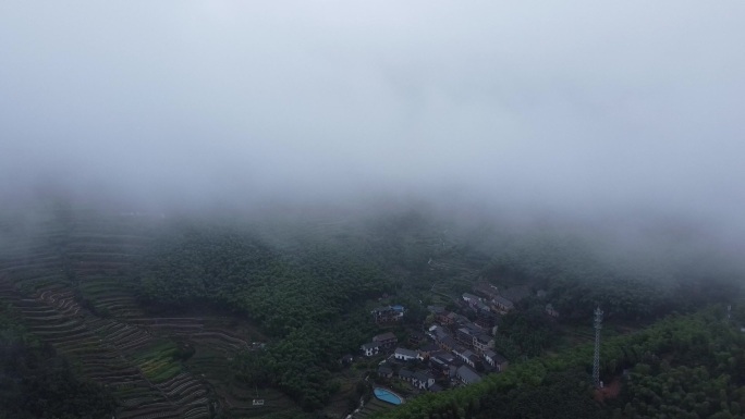 航拍雨天被云雾和竹林环绕的山间农村