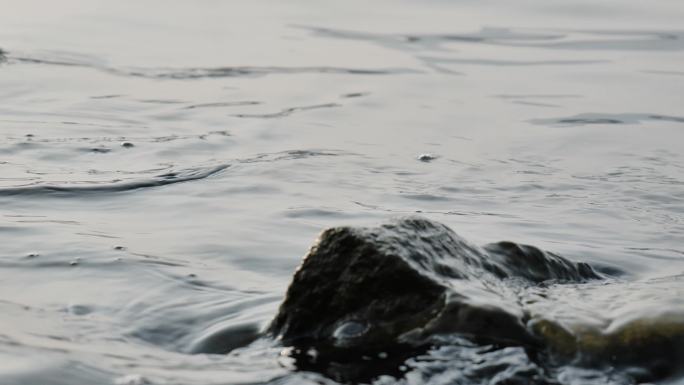 细微水流浪花拍打礁石