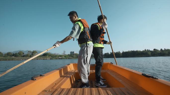 早晨划小船清理湖面的巡河员志愿者