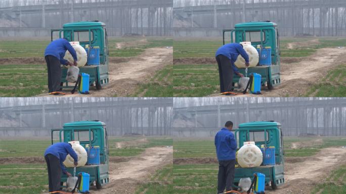 乡村田间地头一名男子在准备打药往桶里灌水