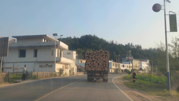 傍晚乡村道路行驶木材运输