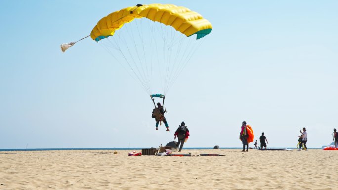 极限跳伞运动蓝天下翱翔的降落伞降落沙滩