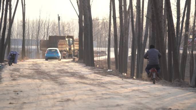 乡村树林间道路上车辆行人经过1