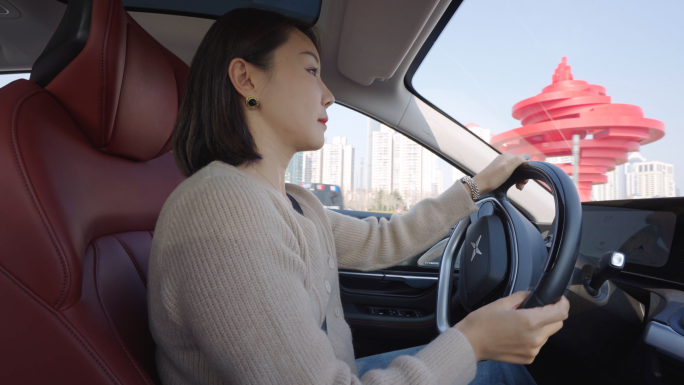 年轻女性开车行驶在城市道路