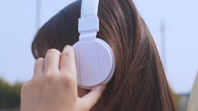 女孩戴上耳机听音乐的动作