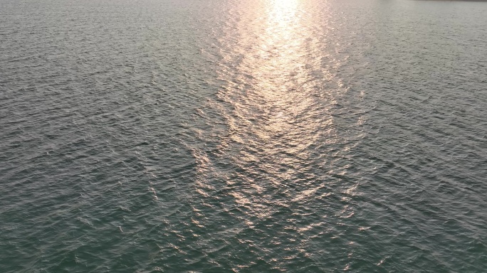 阳光下移动的水面波光粼粼飞越海面行驶飞行