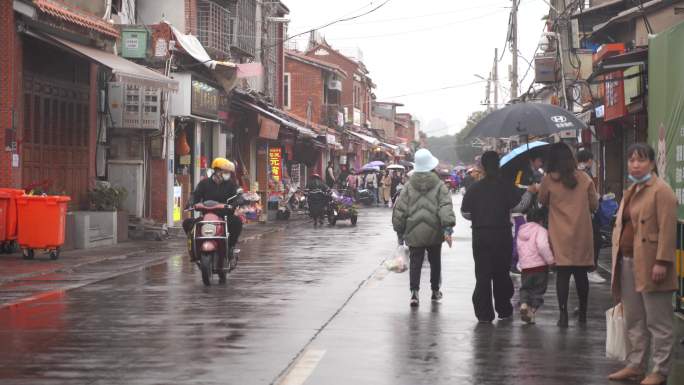 下雨天西街阴雨天街道上撑伞的路人行走视角