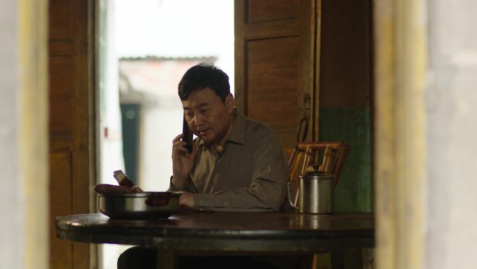 农村父亲男人坐在桌前接电话