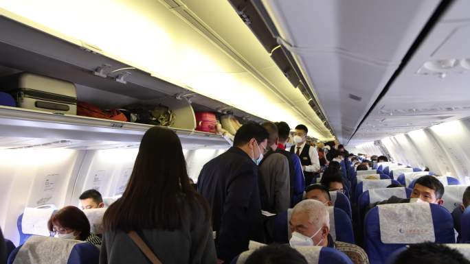 机场登机 飞机上空姐空少帮乘客放行李箱